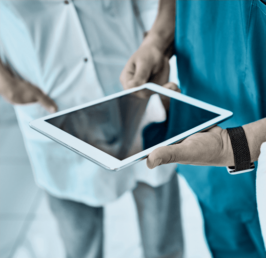 Healthcare professionals collaborating around a tablet device.