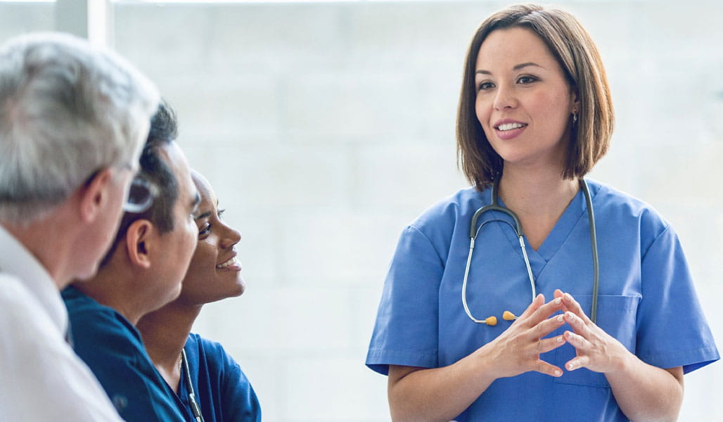 A healthcare professional explains a topic to colleagues.
