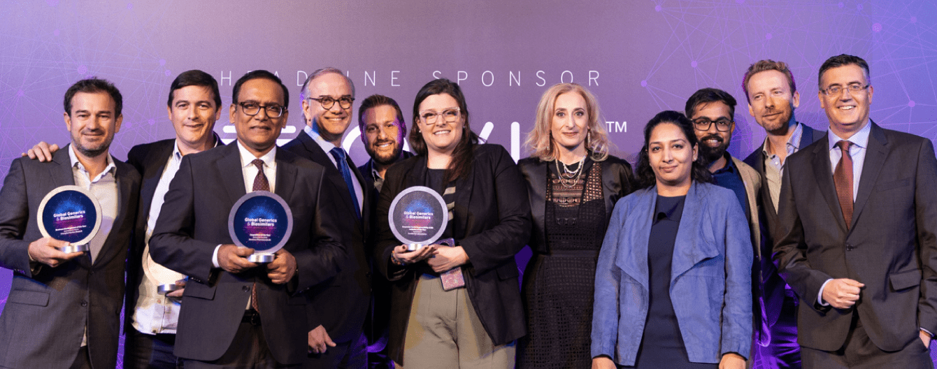 Group of business professionals gathered at a past GGB Awards event holding showcasing their win.