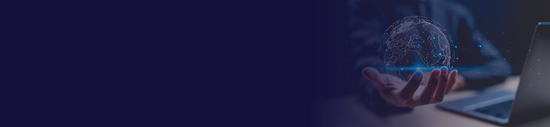 A person in a suit holds a glowing digital globe over a laptop, representing technology and global connectivity.