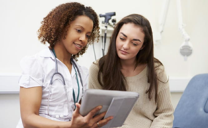 Healthcare professional guiding a patient through their trial journey with digital content and experiences through Citeline Connect.