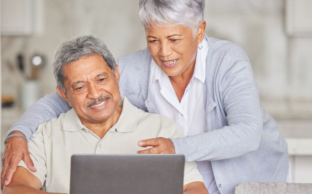 Couple on a laptop device researching information about clinical trials.