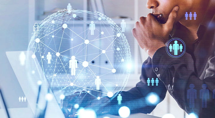 A person interacting with a laptop, surrounded by a digital network of interconnected human icons.