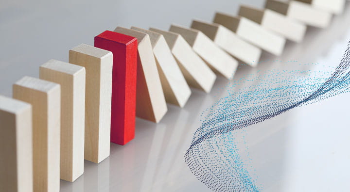 Chain of dominos falling is stopped by a red domino standing out