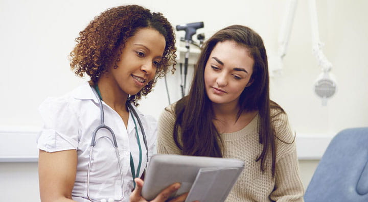 Nurse Showing Patient Test Results On Digital Tablet