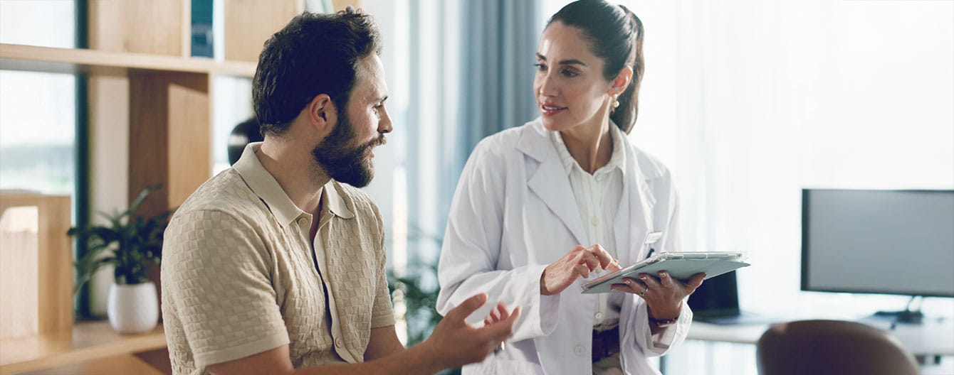 A healthcare professional discusses with a patient clinical trial summary results.