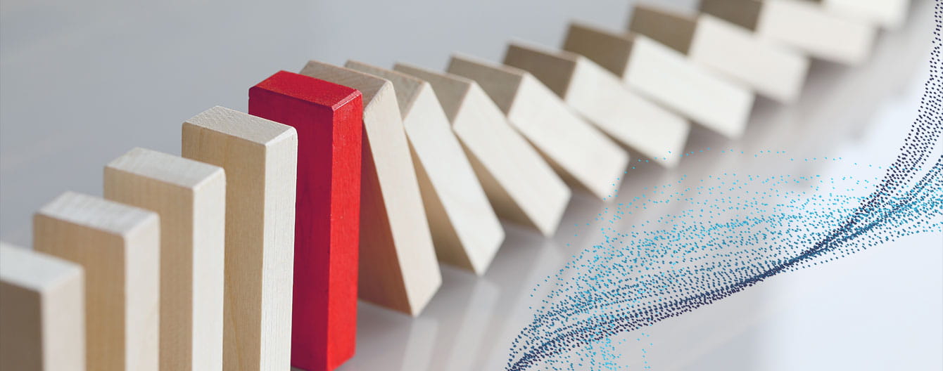 Chain of dominos falling is stopped by a red domino standing out